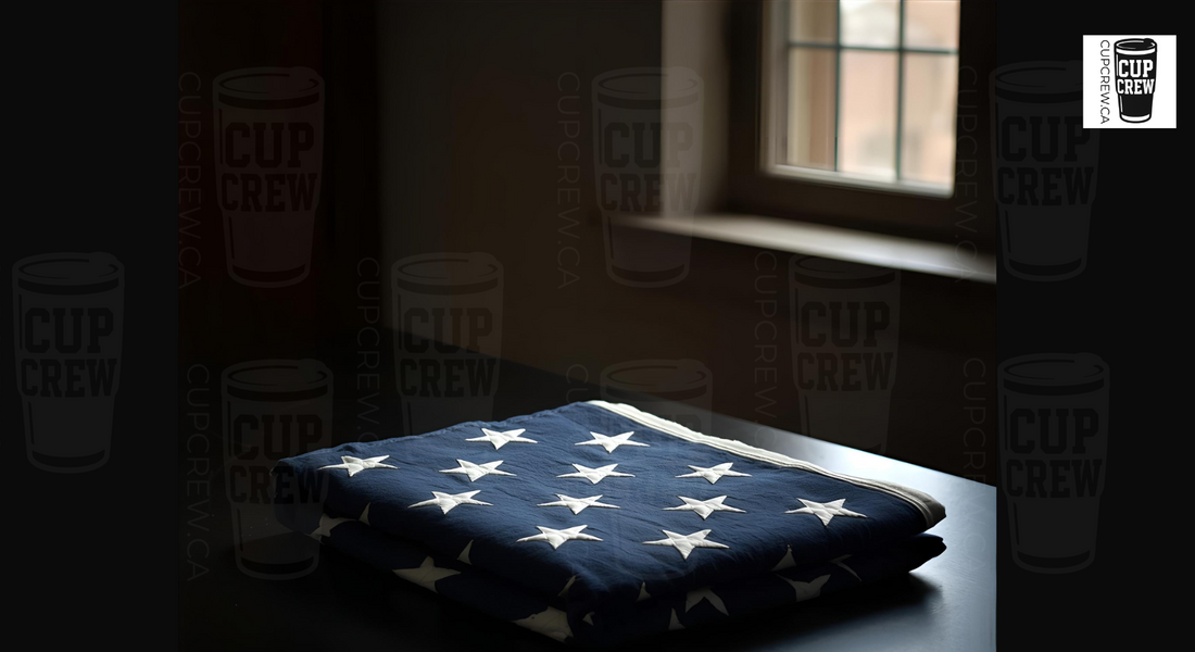 a folded American flag with white stars on a dark surface, with a window and cups with the word "CUP CREW" visible in the background.