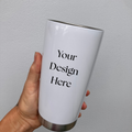 A person's hand holding a white thermos with the text 